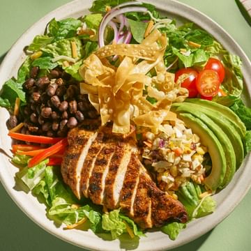Image of White Spot's Southwest Chicken Salad on a green background